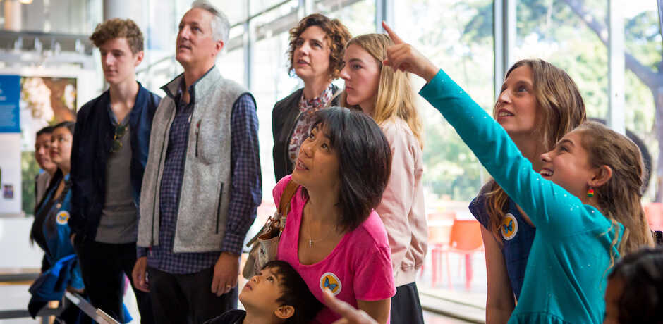 Members watching Gouldian finches in the Color of Life exhibit at the California Academy of Sciences