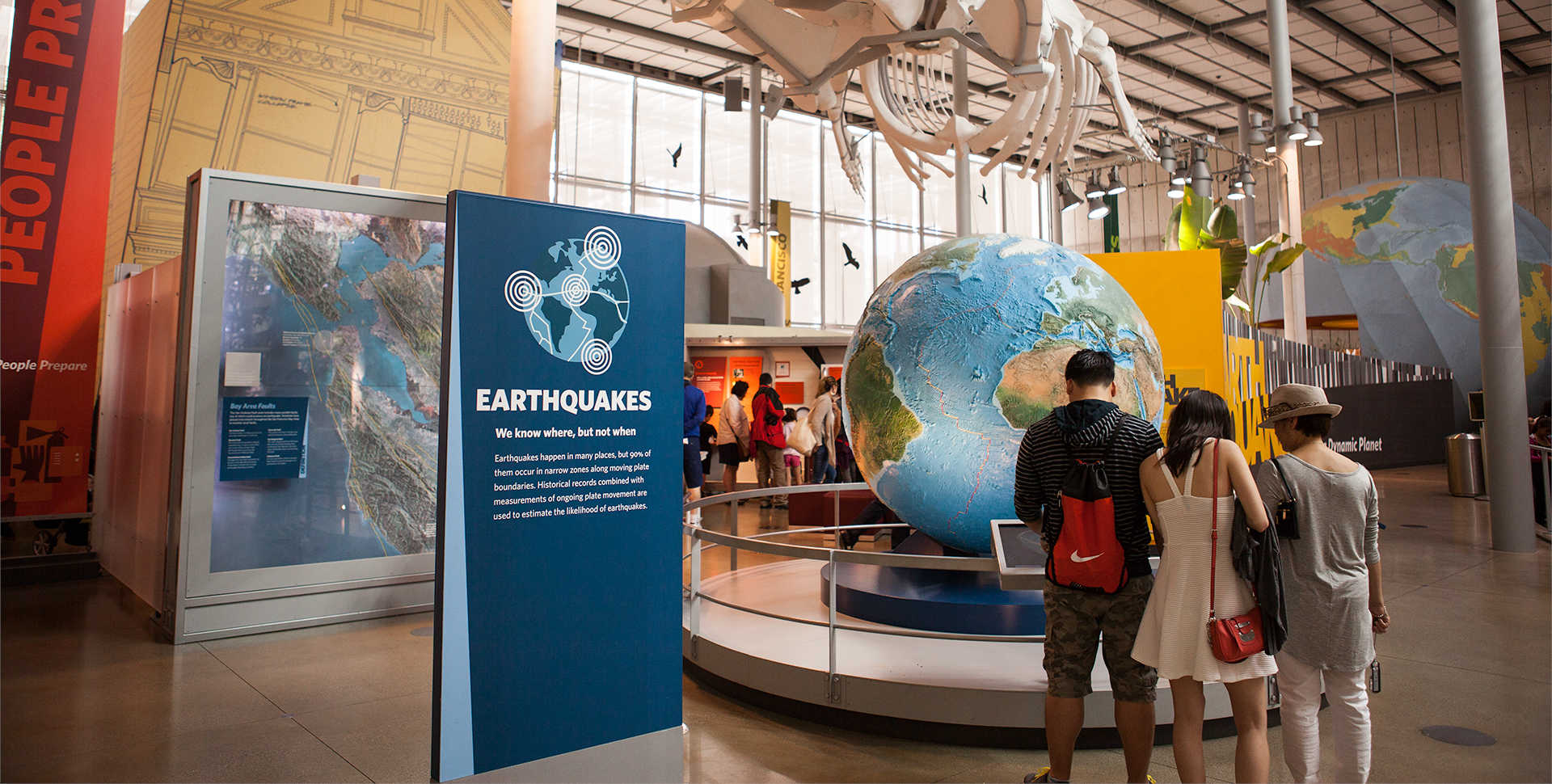 Visitors examine a giant globe at Earthquake, a major exhibit at the California Academy of Sciences