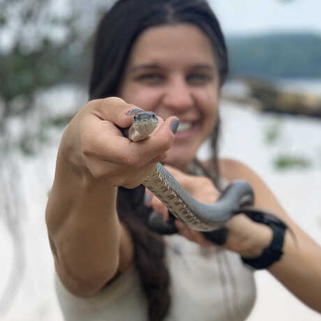 Arianna Kuhn holds a snake close to the camera