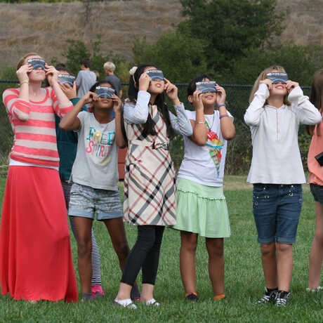 Youth observing the solar eclipse with solar glasses 