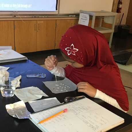 Student investigating water drops