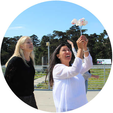 2 female educators experiment with an anemometer on Academy Living Roof