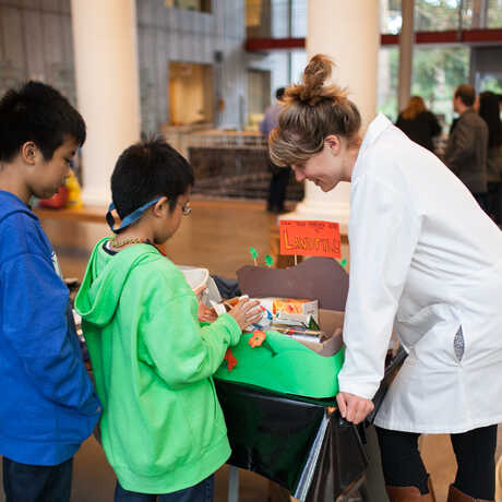 Educator demonstrating an experiment to two kids at the California Academy of Sciences