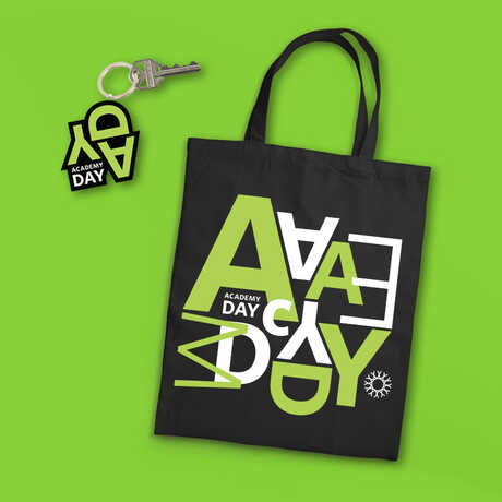 Academy Day keychain and tote bag against green background