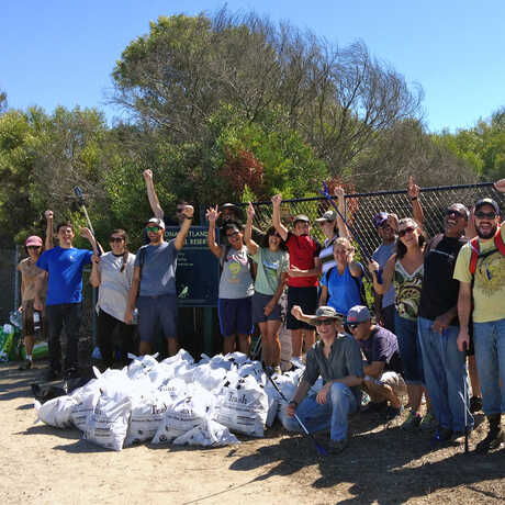 Proud volunteers show off bags of trash they collected during Coastal Cleanup Day