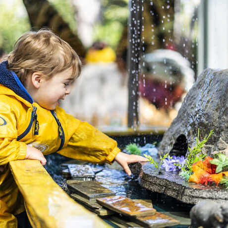 Toddler plays at Riveropolis water activity at Spring in the Garden at the Academy