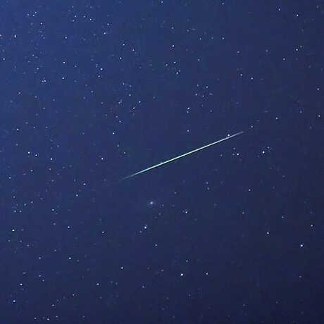 Aquarid meteor streaking across night sky