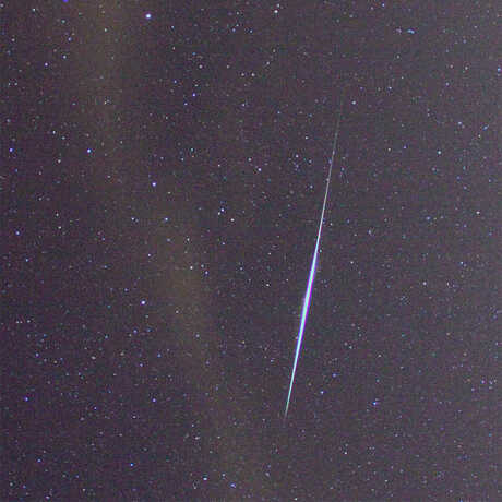 Meteor streaking through a starry sky