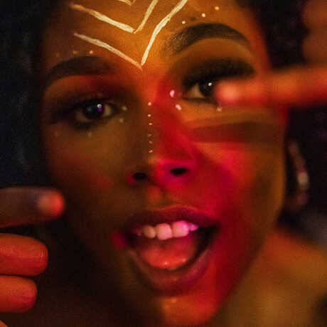 A Black woman in afrofuturist makeup is shown in a close-cropped image.