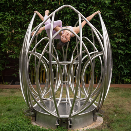 A female dancer contorts in an outdoor sculpture