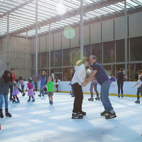 A couple holds hands on the Academy's Holiday Ice Rink