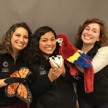 Educators holding puppets have big smiles.