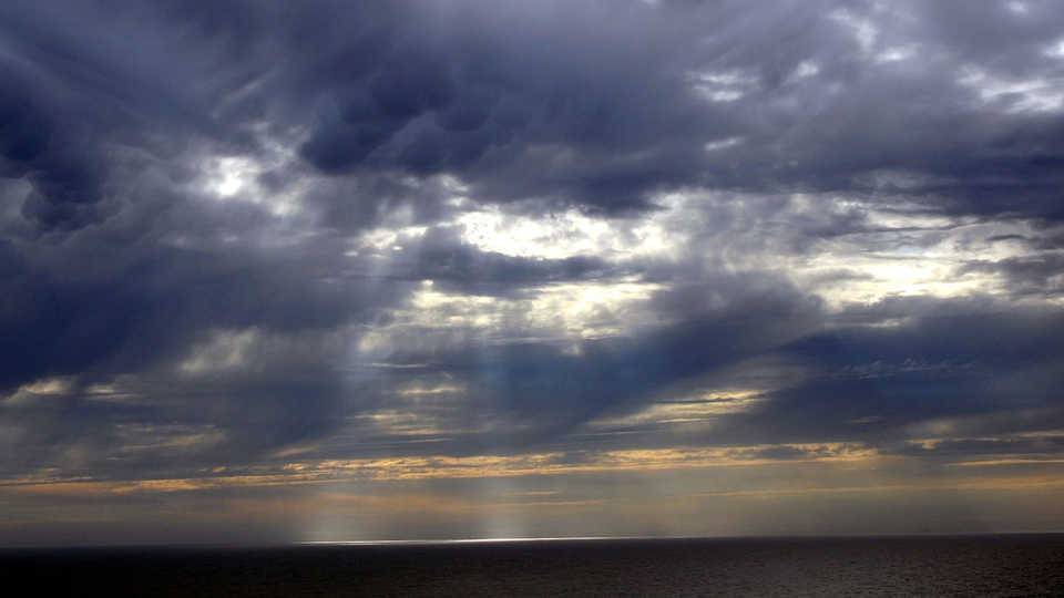 Mammatus clouds and crepuscular rays over the Pacific Ocean.