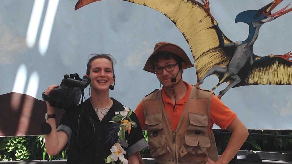 a director and paleontologist character in front of a pterosaur backdrop
