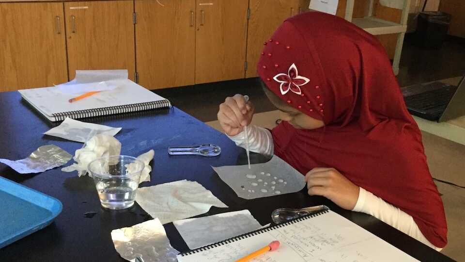 Student investigating water drops