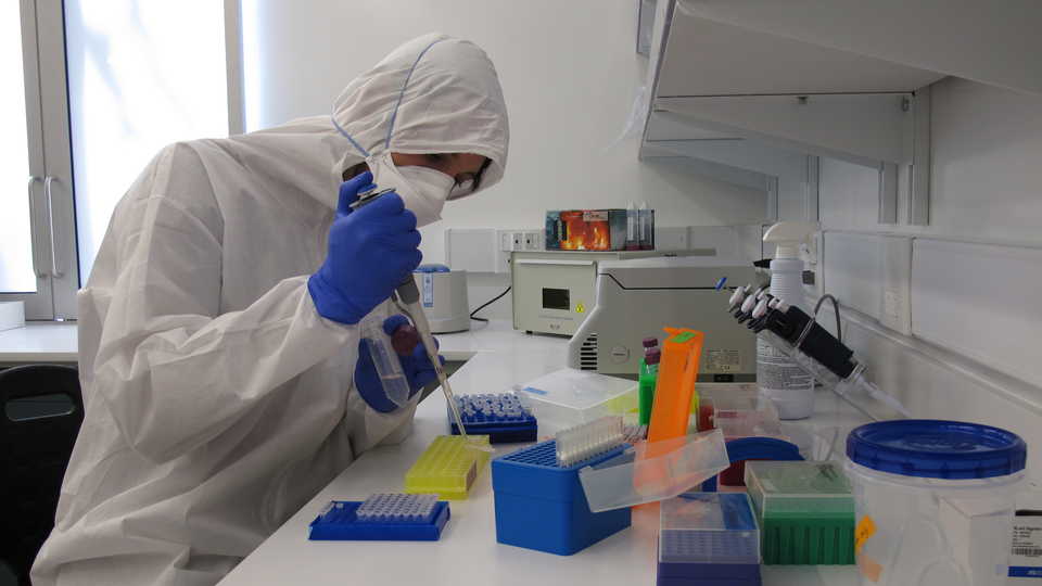 A scientist using a pipette in a lab